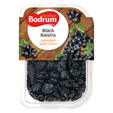 A 250g plastic container of Bodrum Black Raisins features a label with fresh grapes on a wooden surface, highlighting premium Turkish raisins.